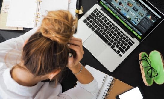 woman at computer with hands in hair, frustrated