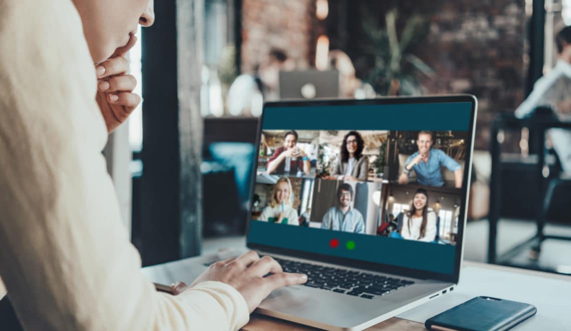 Person leans over laptop with a Zoom meeting with six participants