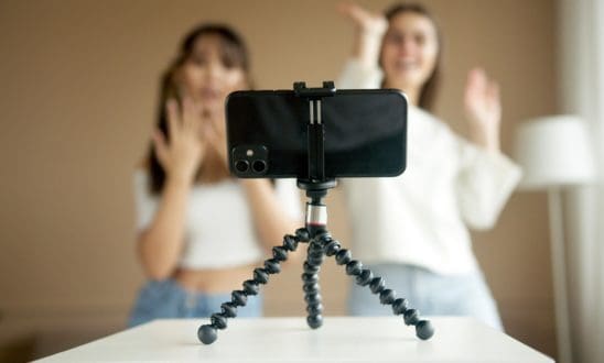 Two influencers dance in front of a cell phone on a tripod